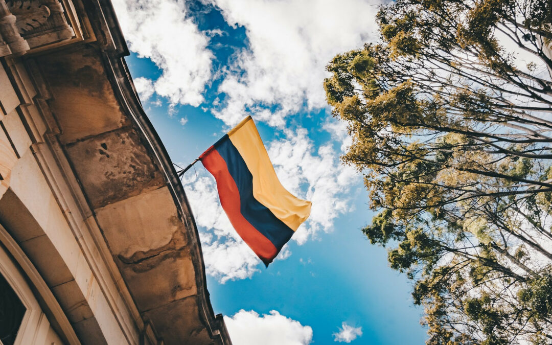 Bandiera della Colombia appesa a un edificio che sventola nel cielo azzurro.